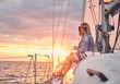 © Fxquadro - Female friends relaxing on the yacht with glasses of wine in the hands, during sunset on the high seas.