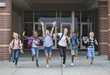 © Brocreative - Group school school kids running as they leave the school building Back to school photo of a diverse group of children wearing backpacks and ready to go home from school
