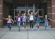 © Brocreative - Group school school kids running as they leave the school building Back to school photo of a diverse group of children wearing backpacks and ready to go home from school