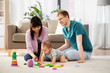 © Syda Productions - family, parenthood and people concept - happy mother, father and baby boy playing toy blocks at home
