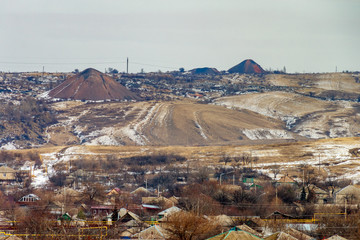 Gloomy winter scene with mining industrial landscape and village of miners