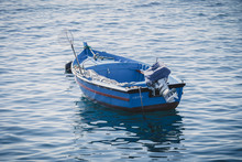 Old Wooden Blue Fishing Boat On Calm Water With A Fishing Net