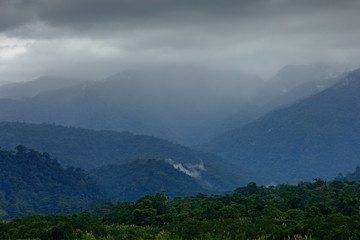 Wall Mural - Foothills of Monteverde Cloud Forest Reserve, Costa Rica. Tropical mountains with grey storm clouds. Rainy day in the forest.