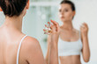 © LIGHTFIELD STUDIOS - cropped shot of girl applying perfume at mirror in bathroom