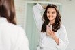 © LIGHTFIELD STUDIOS - beautiful smiling young woman in bathrobe taking selfie with smartphone in bathroom