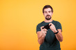 © DC Studio - Adult gamer playing video games on his smartphone on yellow background in studio. Leisure activity