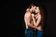 © LIGHTFIELD STUDIOS - side view of sexy shirtless couple hugging and kissing isolated on black