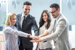 © Bojan - Business team join hands together in office