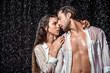 © LIGHTFIELD STUDIOS - portrait of sexy couple in white shirts standing under rain isolated on black
