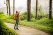 © Sirirat Makprasert - Traveler Woman backpack with water drink in Rain forest; Travel concept.