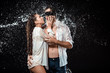 © LIGHTFIELD STUDIOS - portrait of man with black ribbon on eyes hugging sexy girlfriend while swilled with water isolated on black