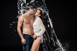© LIGHTFIELD STUDIOS - side view of seductive couple swilled with water isolated on black