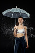 © LIGHTFIELD STUDIOS - portrait of young woman with umbrella swilled with water isolated on black