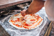 © bnenin - Chef making the pizza. Close-up. Adding cheese on pizza base.