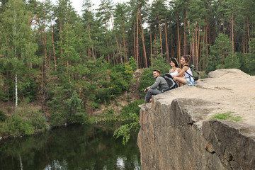 Poster - Young friends on rocky mountain near lake. Camping season