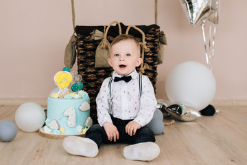 Wall Mural - Baby's first birthday. Cute smiling baby is 1 year old. The concept of a children's party with balloons