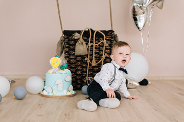 Wall Mural - Baby's first birthday. Cute smiling baby is 1 year old. The concept of a children's party with balloons