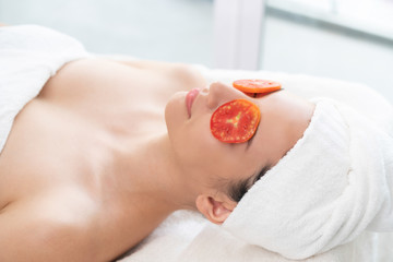 Wall Mural - Woman getting eye nature treatment by tomato.