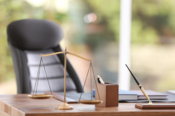 Table with scales of justice in lawyer's office