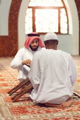 Wall Mural - Two religious muslim man praying together inside the mosque