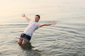 Young man falling in the water with his back