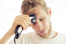 Young Bearded Man Cut His Own Hair With Cutting Shaving Machine Isolated On White Background