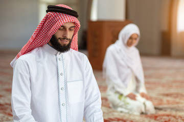 Wall Mural - Muslim man and woman praying in mosque