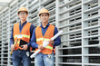 © DragonImages - Portrait of young Vietnamese engineers in hardhats and bright vests working on factory