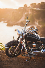 Old Vintage Motorcycle Standing On The Edge Of Cliff In Warm Sunlight At Sunrise, Shiny Details Of Bike Close-up