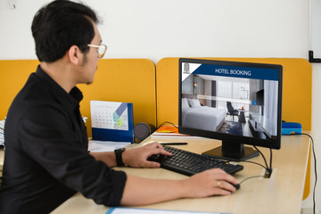 Wall Mural - businessman working on computer, searching for lodging using on-line web service, booking a hotel on