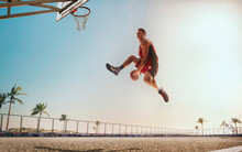 Streetball. Basketball Player In Action On Sunset.