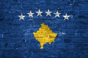 Flag of Kosovo over an old brick wall background, surface