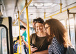 © dusanpetkovic1 - Two best young sweet girl friends standing in a bus and looking in a telephone.