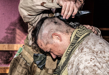 Soldier cuts comrades hair with trimmer. United States marine shaving friends head with clipper in combat conditions. Recruiter preparing for service in military forces by receiving initial haircut