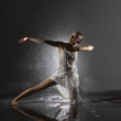 Mujer joven haciendo danza contemporánea con ducha en estudio