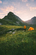 © EVERST - Camping in mountains man alone enjoying sunset landscape Travel adventure lifestyle concept active summer vacations with tent in wilderness