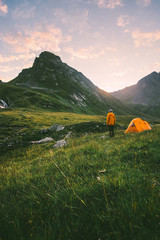 Wall Mural - Camping in mountains man alone enjoying sunset landscape Travel adventure lifestyle concept active summer vacations with tent in wilderness