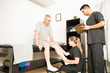 © AntonioDiaz - Physiotherapist Examining Patient's Leg While Colleague Holding Clipboard In Hospital