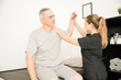 © AntonioDiaz - Physiotherapist Moving Injured Hand Of Elderly Man