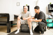 © AntonioDiaz - Physiotherapist Helping Patient Sitting On Exercise Ball