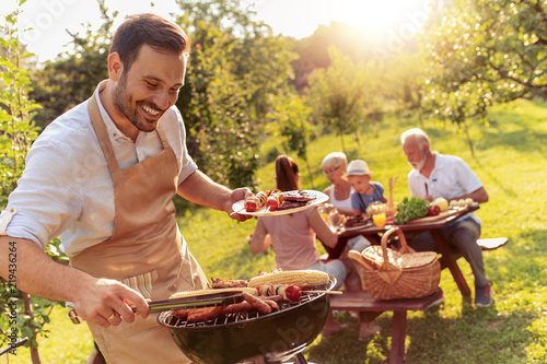 Fotomural Happy family having barbecue party in backyard