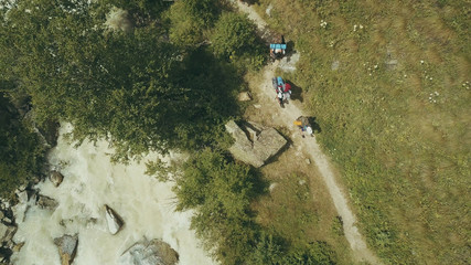 Wall Mural - tourist group crossing the river in mountain. aerial view mountain river