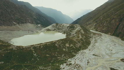 Wall Mural - aerial view hiking group walking along mountain river. climbing a mountain