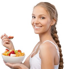 Wall Mural - Attractive young woman holding salad and smiling at camera