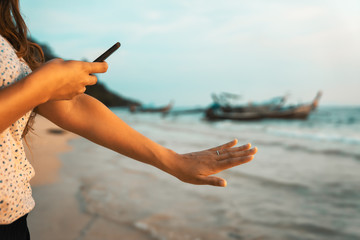 Wall Mural - happy young woman on beach photographing her engagement ring after wedding proposal