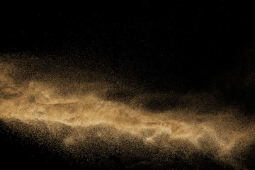 Wall Mural - Dry river sand with stone explosion. Yellow colored sand splash agianst dark background.
