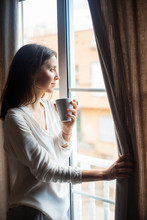Happy Beautiful Woman Drinking Hot Coffee Looking On Window At Home