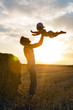© saulich84 - father throws his son into the sky next to a haystack