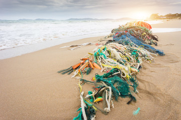 Outdoor view of fishing net and ropes garbage in the beach, every day waste accumulates on the beach from ocean currents effect