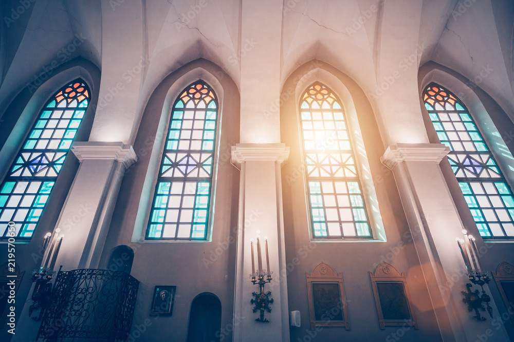 Minsk, Belarus, April 15, 2018: Church of Holy Trinity known as St. Roch on the Golden Hill is a Roman Catholic church in Minsk, view of the stained glass windows and sunlight through them - obrazy, fototapety, plakaty 